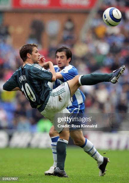 Michael Owen of Newcastle is challenged by Leighton Barnes of Wigan during the Barclays Premiership match between Wigan Athletic and Newcastle United...