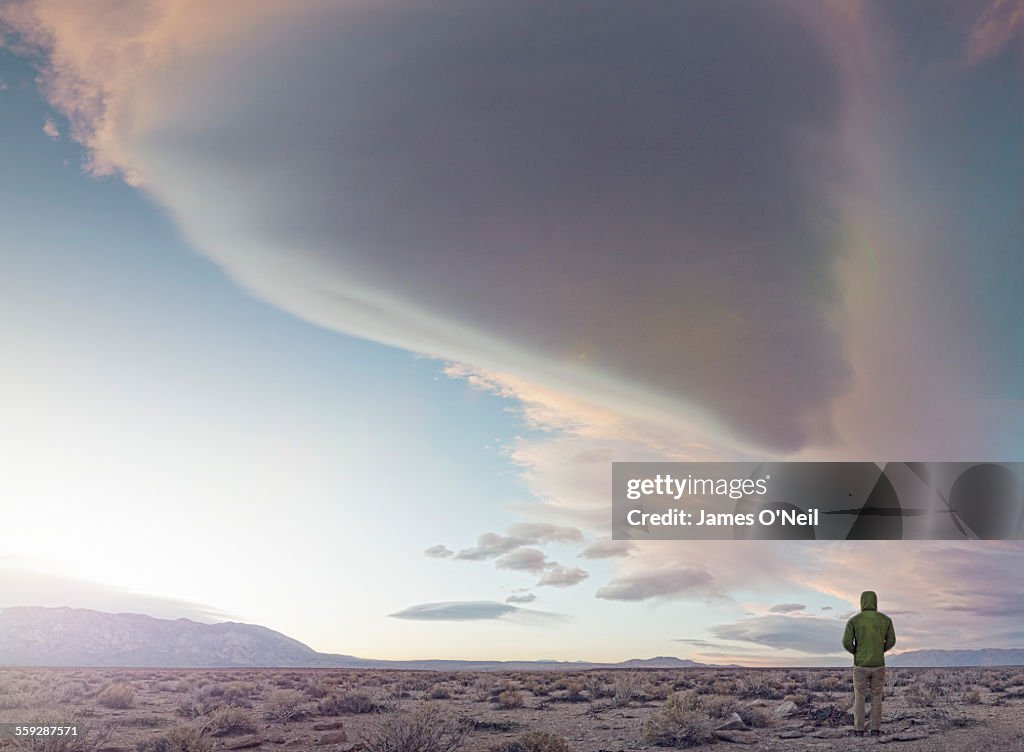 Male standing under dramatic clouds
