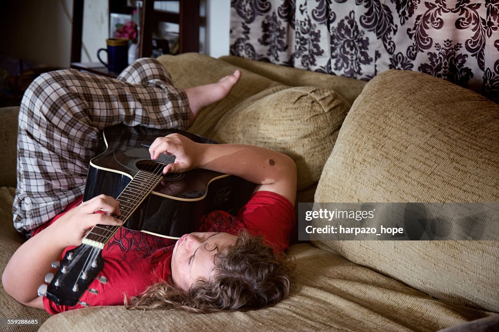 Young man playing his guitar