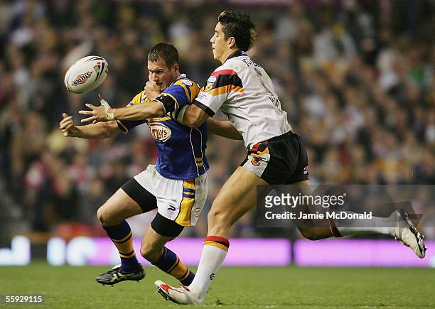 Danny McGuire of Leeds offloads as he is tackled by Bradford's Shontane Hape during the Engage Super league Grand Final between Leeds Rhinos and...
