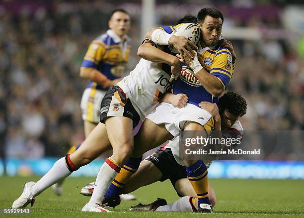 Willie Poching of Leeds is tackled by Shontane Hape and Jamie Langley of Bradford during the Engage Super league Grand Final between Leeds Rhinos and...