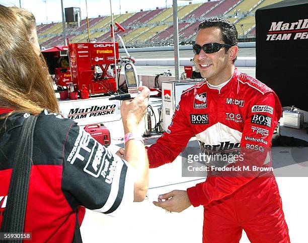 Race car driver Helio Castroneves signs an autograph for a fan during the Toyota Indy 400 at the California Speedway on October 15, 2005 in Fontana....