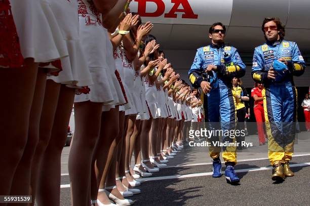 Giancarlo Fisichella of Italy and his team mate and World Champion Fernando Alonso of Spain and Renault walk on the pit lane to attend the driver's...