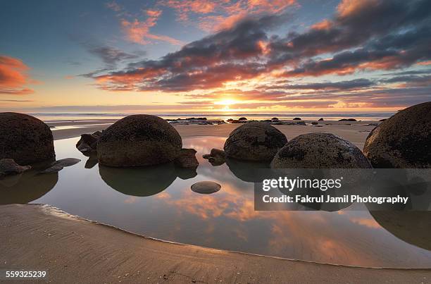 moeraki boulders sunrise and reflection - moeraki boulders ストックフォトと画像