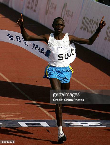Benson Cherono of Kenya celebrates as he crosses the finish line during the Beijing International Marathon on October 16, 2005 in Beijing, China....