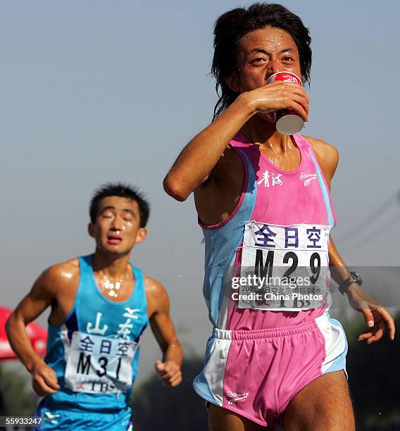 Chinese athlete drinks water during the Beijing International Marathon on October 16, 2005 in Beijing, China. Benson Cherono of Kenya and Sun Yingjie...