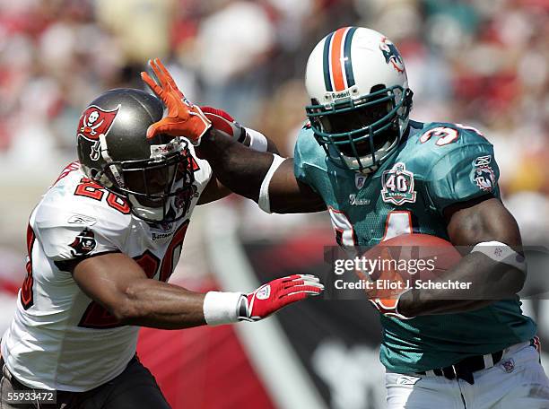 Running back Ricky Williams of the Miami Dolphins is chased out of bounds by cornerback Ronde Barber of the Tampa Bay Buccaneers on October 16, 2005...