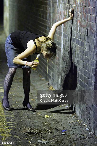 Woman vommits in the street after leaving a pub in Bath on October 15, 2005 in Bath, England. Pubs and clubs prepare for the new Licensing laws due...