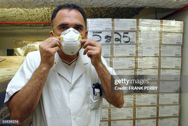 Alain Champain, nurse of the Nantes's hospital, West of France, wears a face mask, 17 October 2005, in the store of the establishment where 48,000...