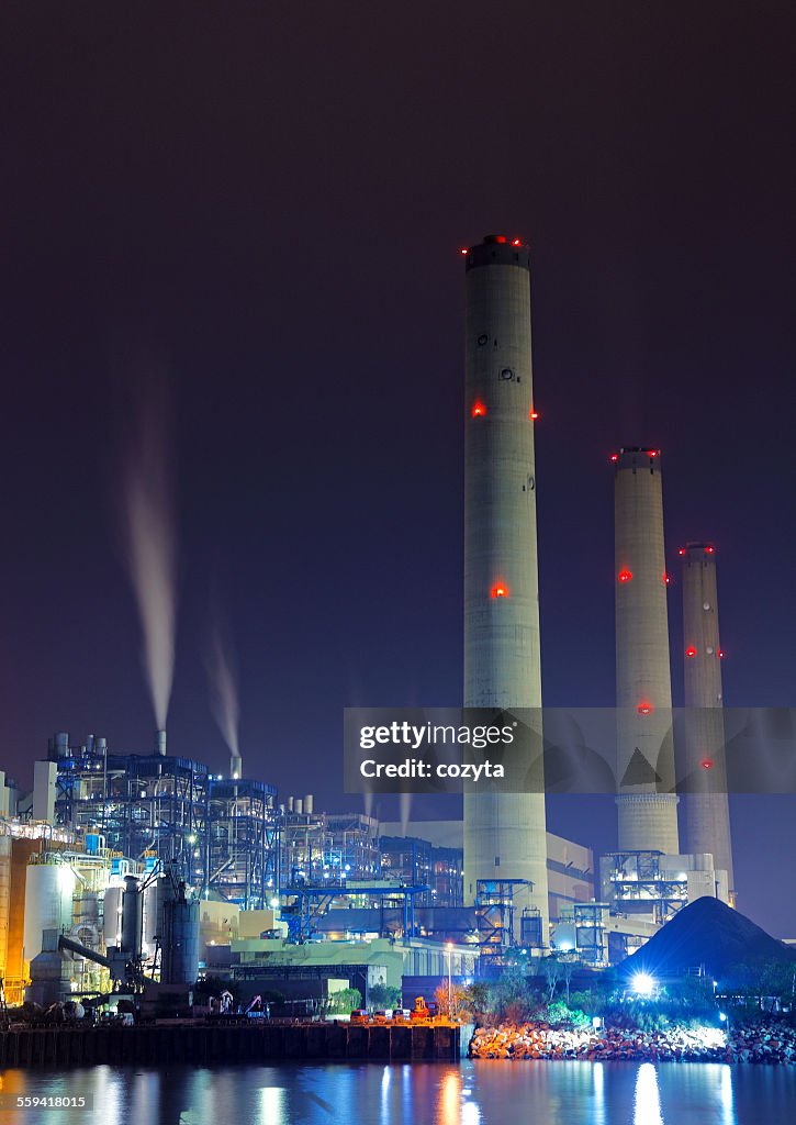 Power station at night with smoke