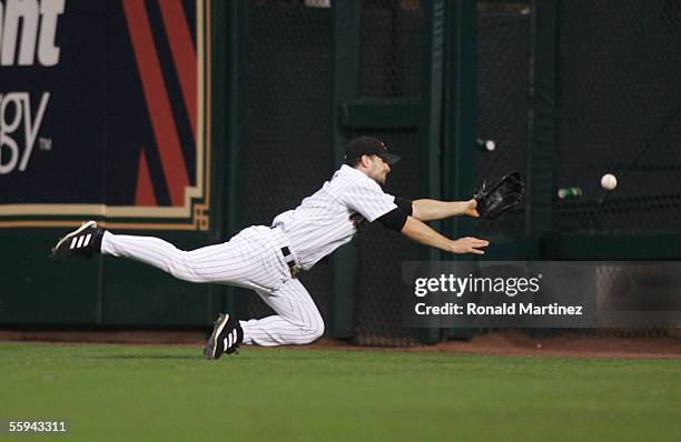 Outfielder Chris Burke of the Houston Astros makes a diving attempt at a double hit by Yadier Molina of the St. Louis Cardinals during the second...