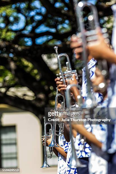 Trumpet players in aloha shirts from the Hawaiian Kamehameha School marching band, marching and playing in the annual local downtown King Kamehameha...