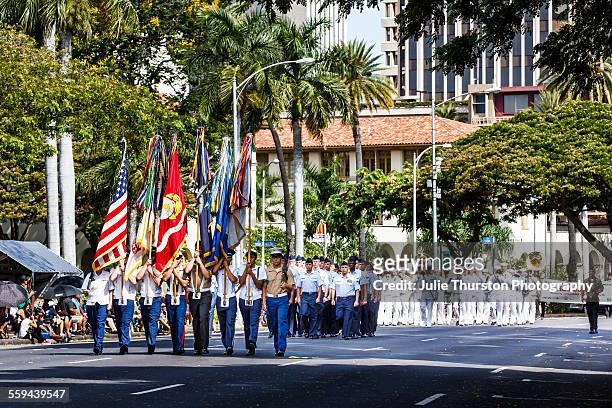 Navy Pacific Band wearing white military uniforms, following a color guard, marching and playing brass instruments in the annual downtown King...