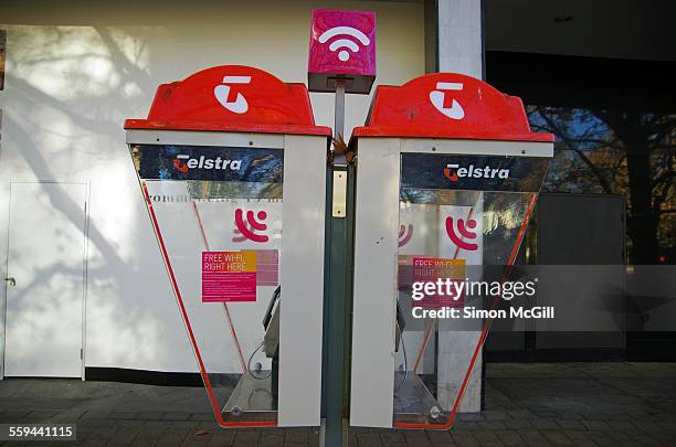 Telstra pay phone kiosks with a pink wi-fi hotspot sign on top on City Walk, Canberra, Australian Capital Territory, Australia