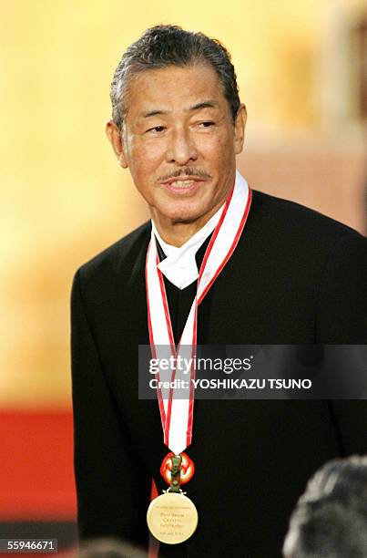 Japanese fashion designer Issey Miyake smiles after receiving the gold medal of the Praemium Imperiale at the awarding ceremony in Tokyo, 18 October...