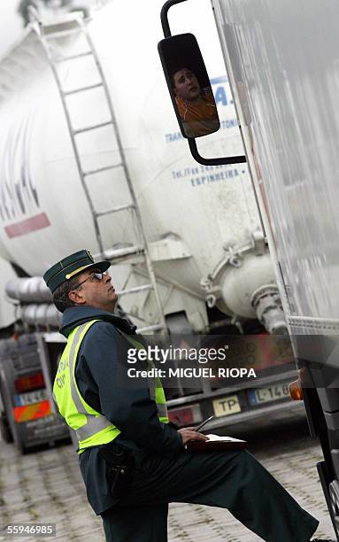 Member of the Guardia Civil talks to striking lorry drivers during a mass transport strike by road hauliers in Tui, near the Portuguese border, 18...