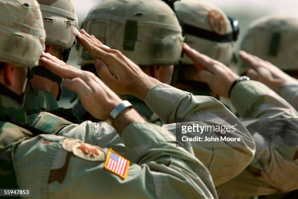 Army soldiers salute during a memorial service for Sgt. Robert Tucker at a military base October 18, 2005 in Dujail, Iraq. Tucker from Cookeville,...