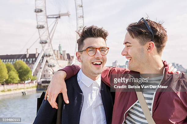 gay couple standing near london eye - millennium wheel imagens e fotografias de stock