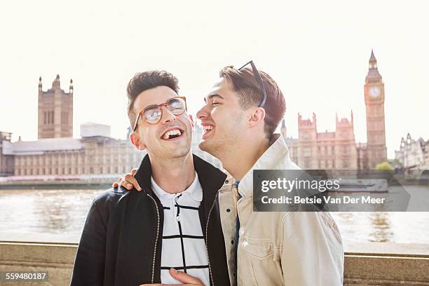 gay couple laughing, standing near big ben - gay man stock pictures, royalty-free photos & images