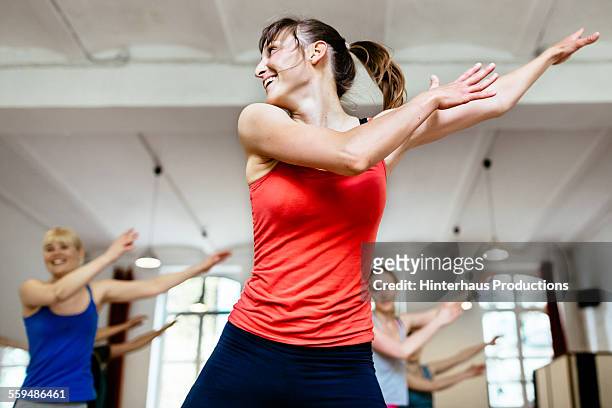 female trainer infront of her aerobics class - sports training stock-fotos und bilder