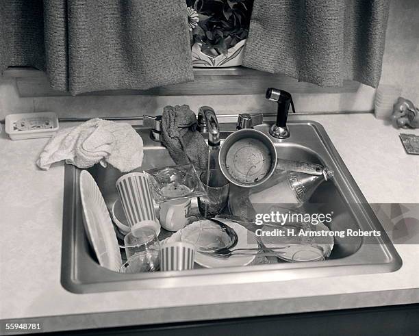 Circa 1960s: Kitchen Sink Full Dirty Unwashed Dishes Glasses Cups Messy Mess Neglect Sinks Kitchens.