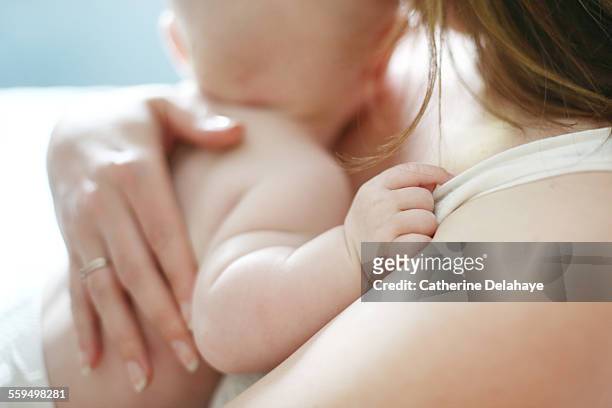 a baby in the arms of his mum - baby stock-fotos und bilder