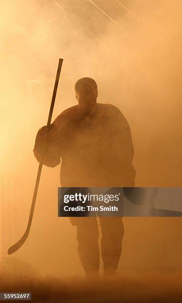 Edmonton Oiler great Paul Coffey is silhouetted in smoke as he walks onto the ice at the beginning of a special ceremony to raise his number 7...
