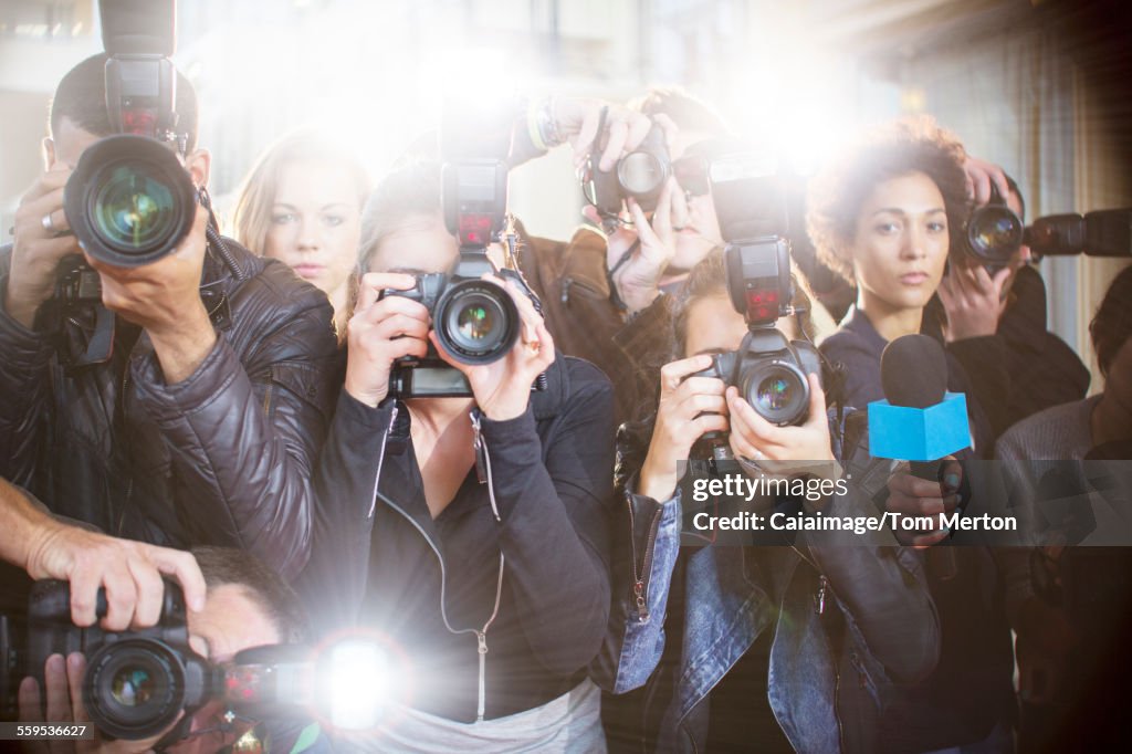 Retrato de fotógrafos paparazzi serios apuntando cámaras