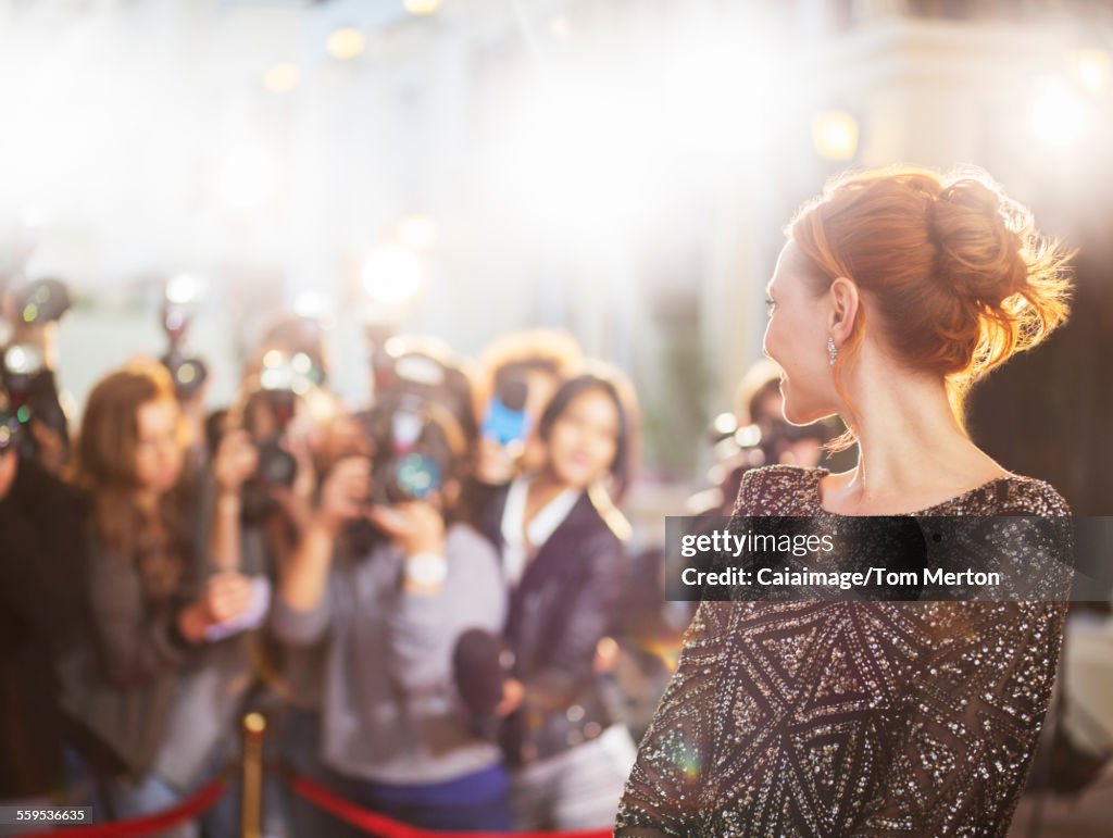 Prominente drehen sich um und lächeln bei Paparazzi-Fotografen bei Veranstaltung