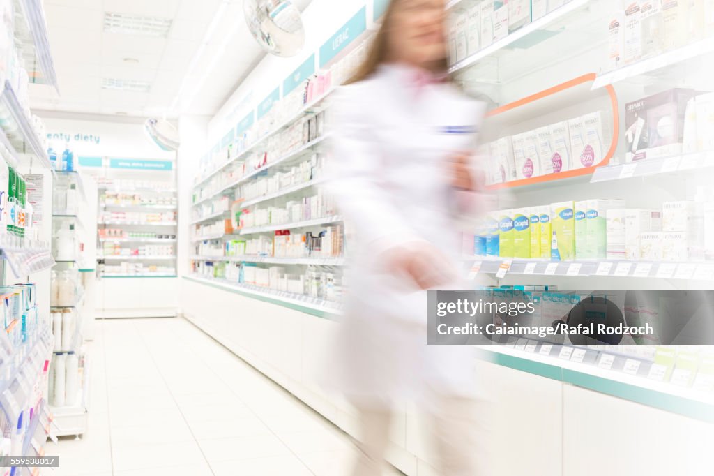 Farmacista che cammina nel corridoio della farmacia