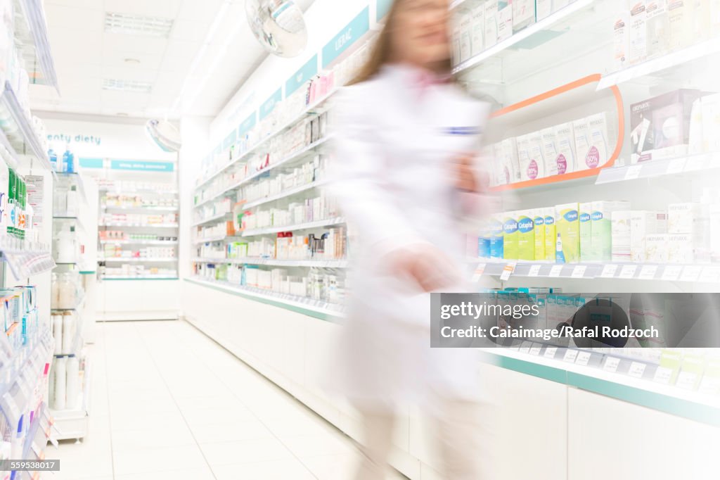 Pharmacist walking in aisle of pharmacy