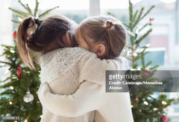 クリスマスツリーの前で抱き合う女の子