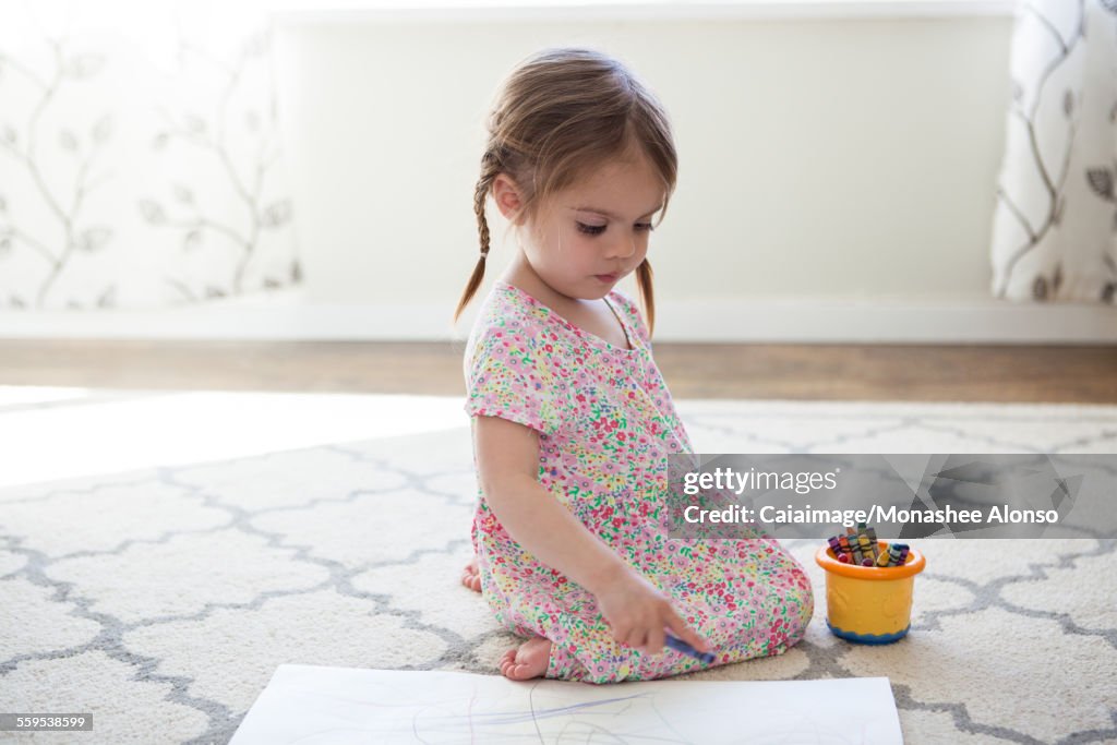 Fille en robe dessinant avec des crayons