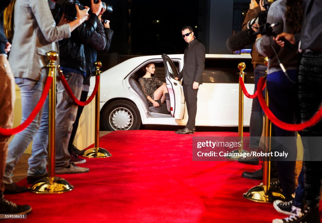 Bodyguard opening limousine for celebrity arriving at red carpet event