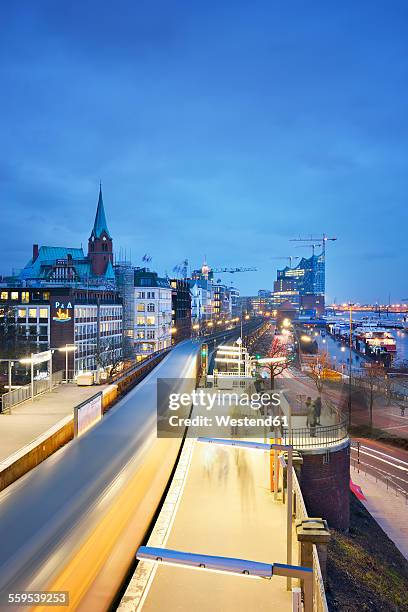 germany, hamburg, subway station landungsbruecken at blue hour - mensch im hintergrund stock-fotos und bilder