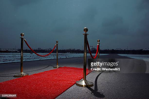 red carpet on street, city in the background, dark clouds - レッドカーペット ストックフォトと画像
