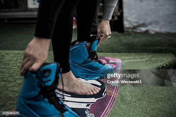 germany, garbsen, wakeboarder undressing shoes - entkleiden stock-fotos und bilder