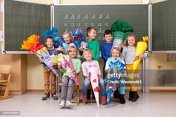 group of happy pupils with school cones in classroom - first day of school fotografías e imágenes de stock