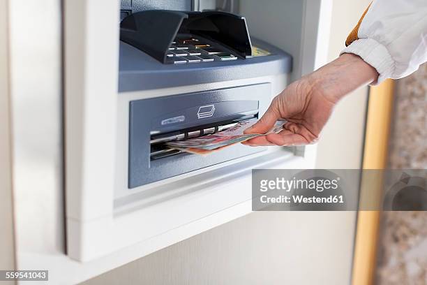 woman at cash machine - atm cash stock pictures, royalty-free photos & images