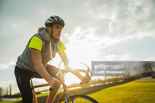 germany, mannheim, young man riding bicycle - cycling helmet stock pictures, royalty-free photos & images