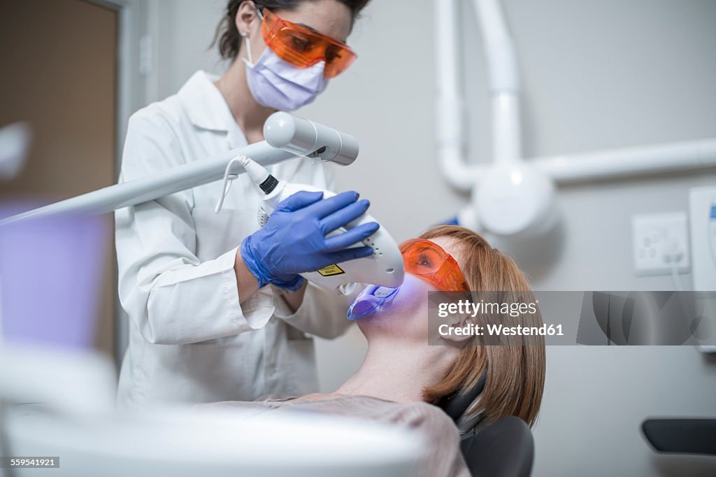 Denist using tooth bleaching machine