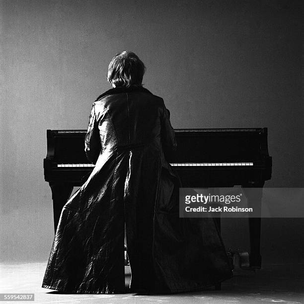Portrait of British musician Elton John, dressed in a leather duster as he plays piano, 1970.