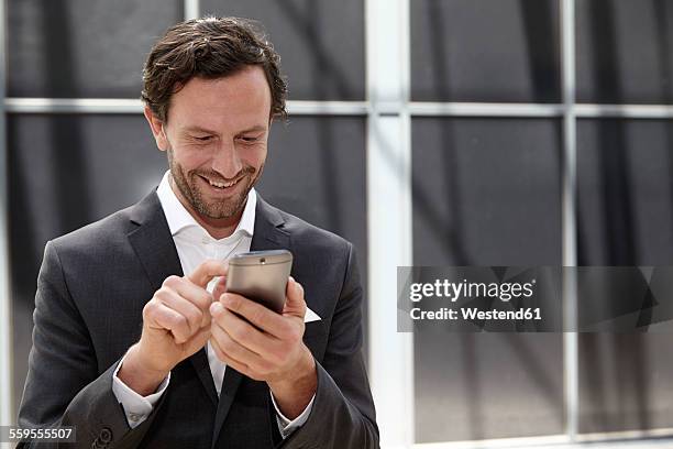 businessman using smartphone in a modern building - suit hand stock-fotos und bilder