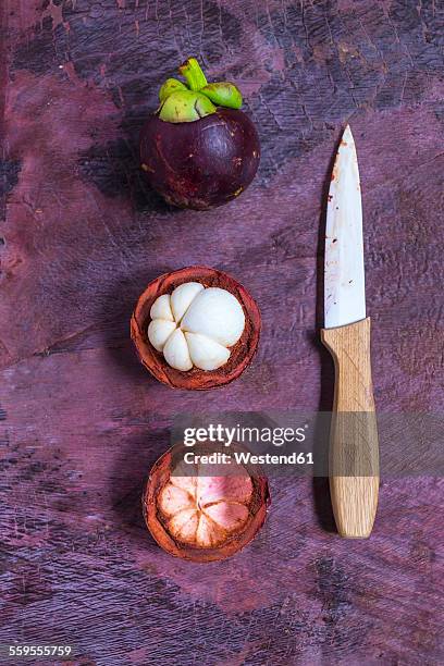 whole and opened mangosteens and a kitchen knife - mangosteen 個照片及圖片檔