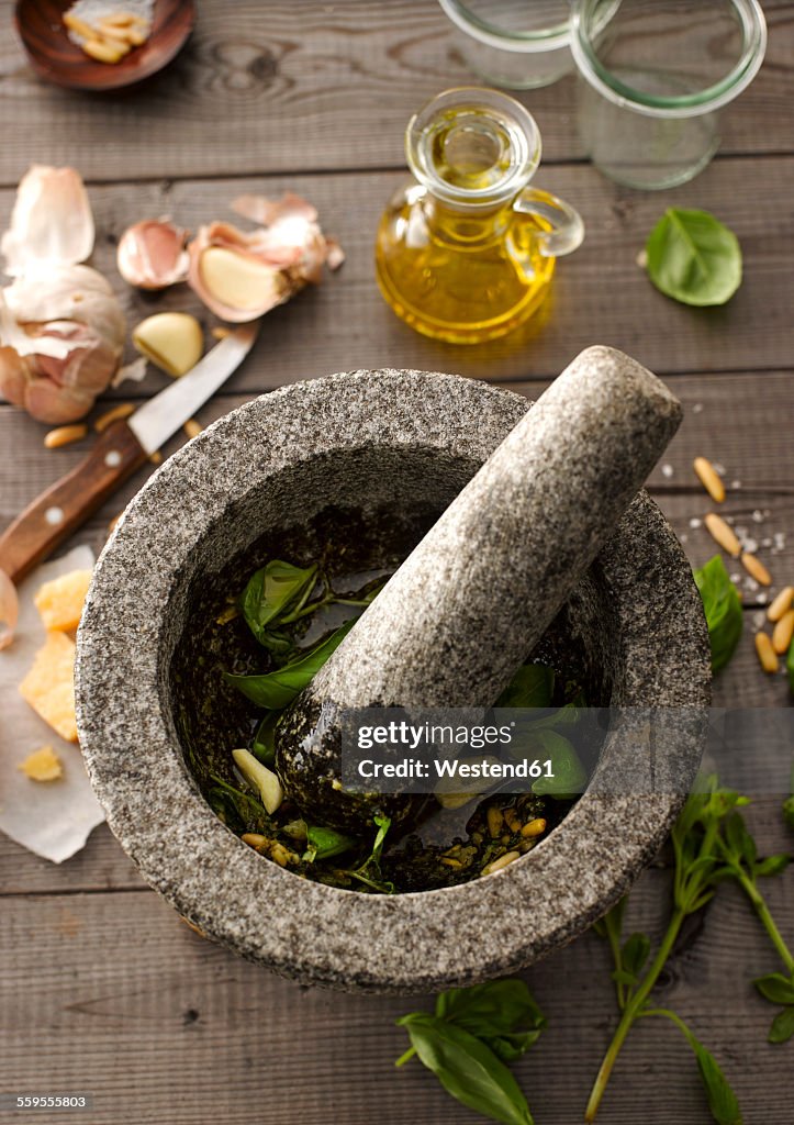 Preparing basil pesto with mortar