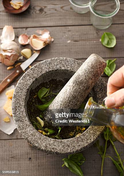 preparing basil pesto with mortar - mortar and pestle photos et images de collection