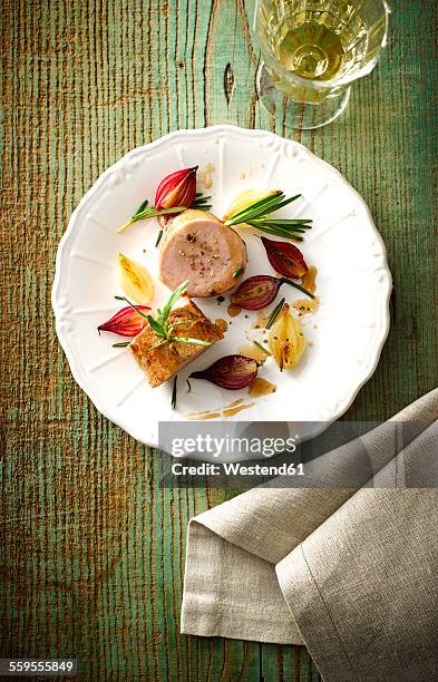 plate of veal slices, candied and caramelized shallots and a glass of white wine - kalfsvlees stockfoto's en -beelden