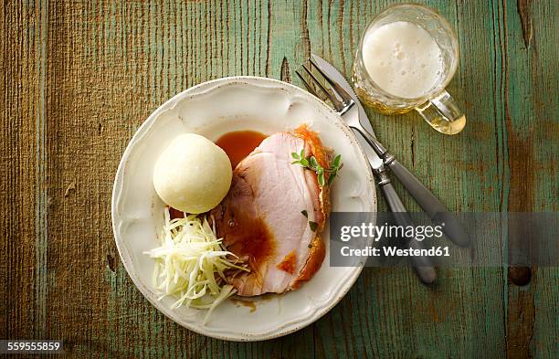 plate of pork roast with crackling, gravy, white cabbage and dumpling - roast pig stock pictures, royalty-free photos & images