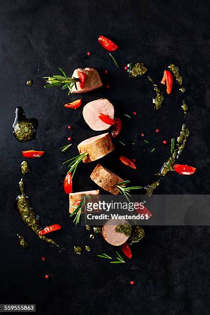 arrangement of veal slices, basil pesto, slices of red bell pepper and red peppercorns on black background - bell pepper stockfoto's en -beelden