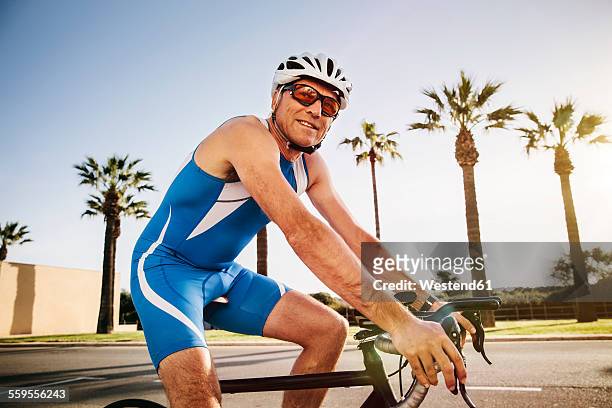 spain, mallorca, sa coma, smiling triathlet training on bicycle - 50 sombras fotografías e imágenes de stock